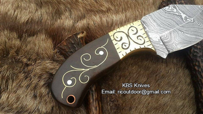 Close-up of the 2.75-inch Damascus steel blade with intricate patterns.