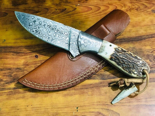 Deer skinning knife with Raindrops Damascus steel blade and antler horn handle.
